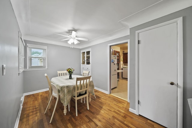 dining room with washer / clothes dryer, ceiling fan, and wood-type flooring