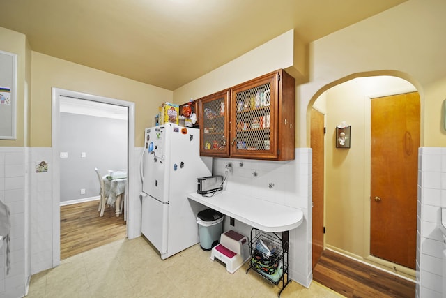 kitchen featuring white refrigerator, backsplash, and light hardwood / wood-style flooring