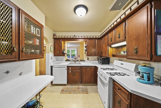 kitchen with light tile patterned floors, white appliances, tasteful backsplash, and sink