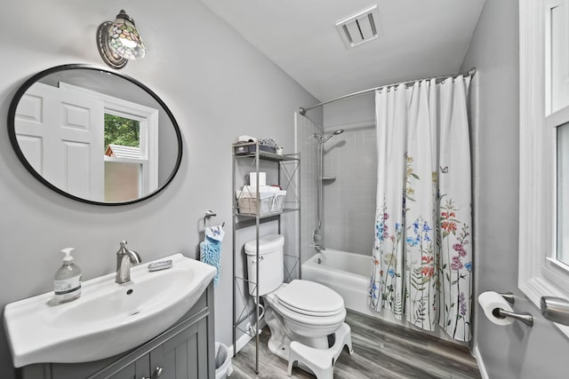 full bathroom featuring hardwood / wood-style flooring, vanity, toilet, and shower / tub combo