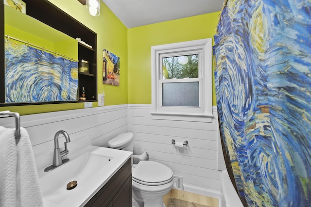 bathroom with hardwood / wood-style floors, vanity, toilet, and walk in shower