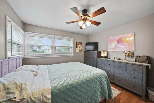 bedroom featuring wood-type flooring, multiple windows, and ceiling fan