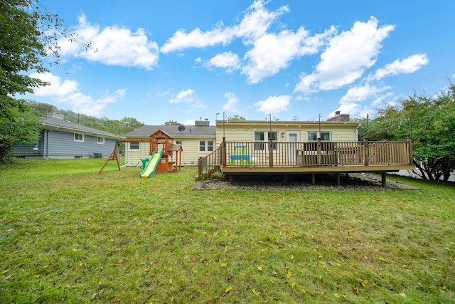 back of house with a playground, a yard, and a deck