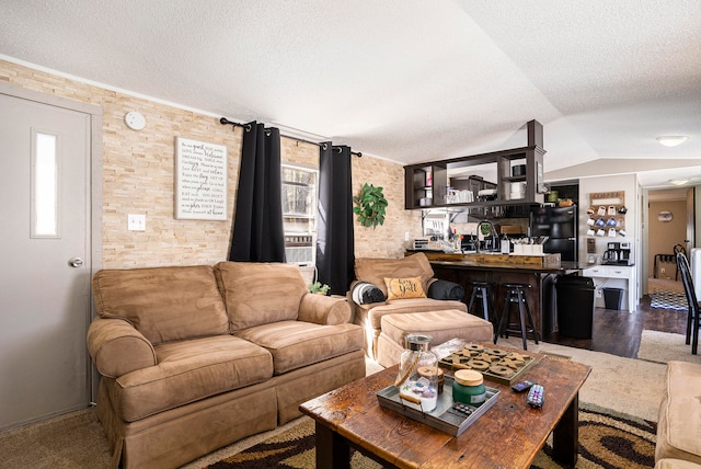 living room featuring a textured ceiling, lofted ceiling, and hardwood / wood-style flooring