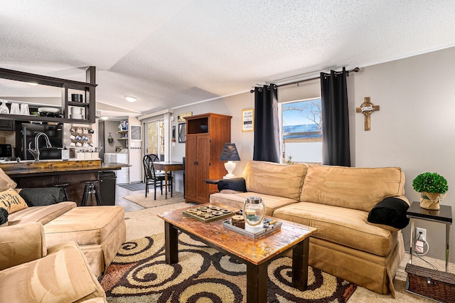 carpeted living room featuring a textured ceiling, sink, and lofted ceiling