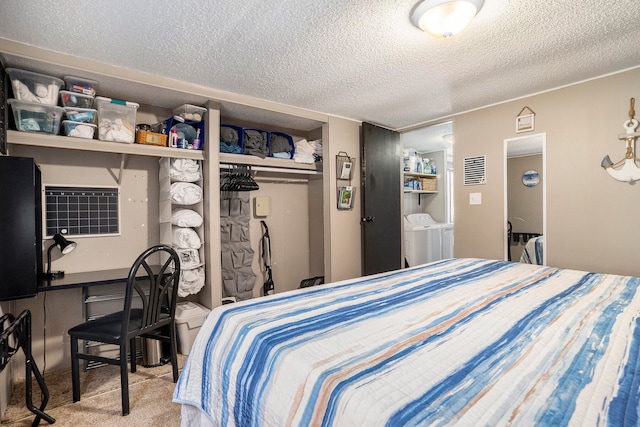 carpeted bedroom featuring independent washer and dryer, a textured ceiling, and a closet