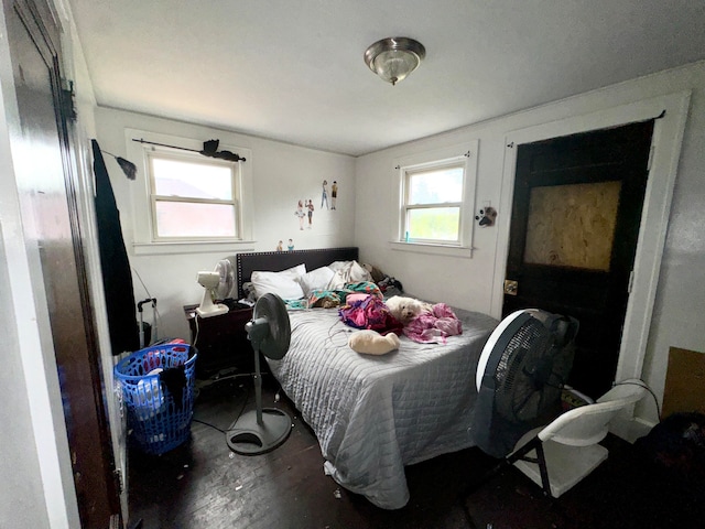 bedroom featuring dark hardwood / wood-style flooring and multiple windows