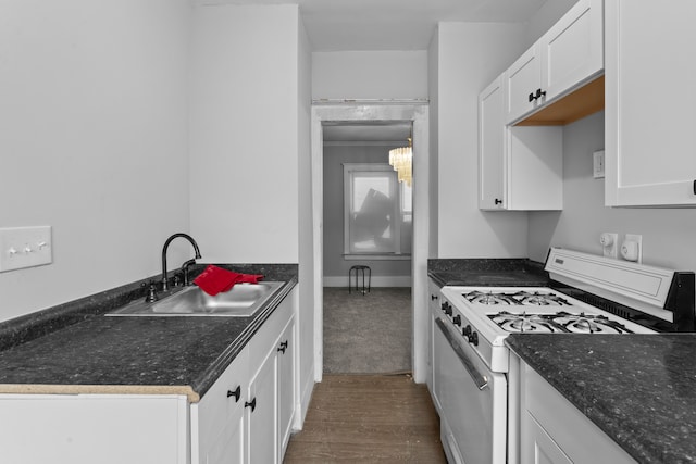 kitchen with pendant lighting, sink, dark hardwood / wood-style flooring, white cabinetry, and white range with gas cooktop