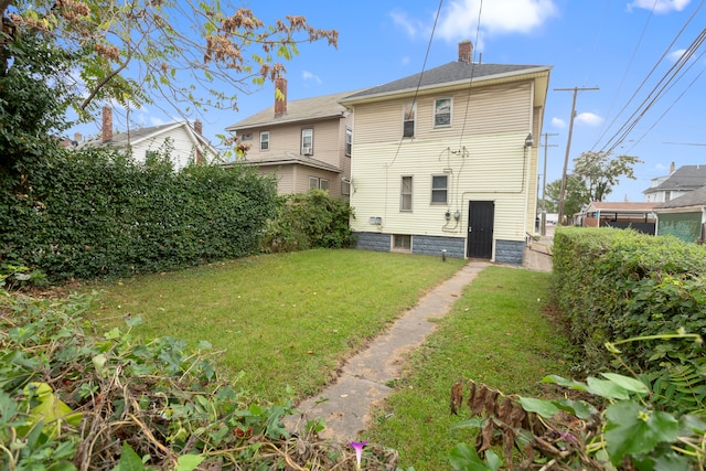 rear view of property with a yard