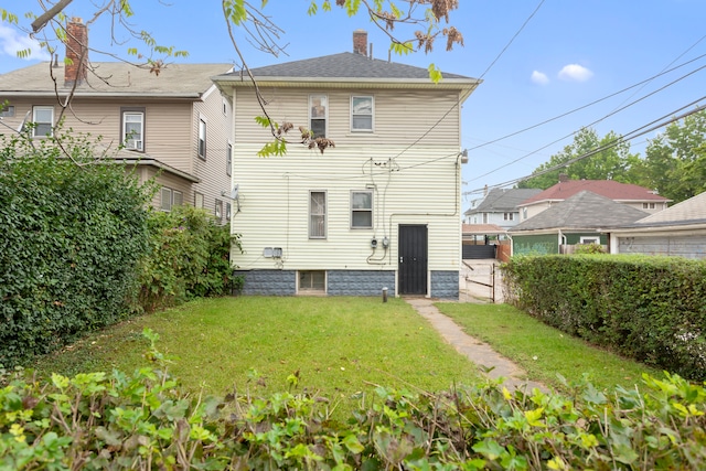 rear view of property featuring a yard