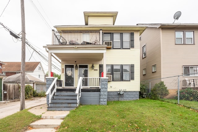 view of front facade with a porch, a balcony, and a front yard