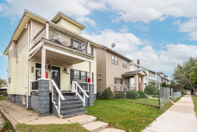 view of front of home featuring a porch, a balcony, and a front lawn