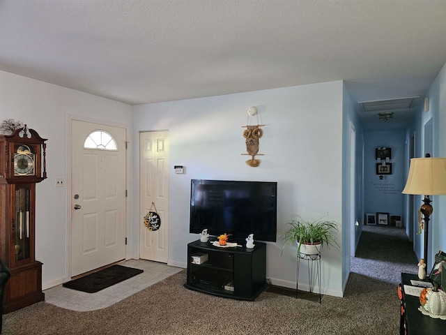 carpeted foyer entrance featuring a textured ceiling