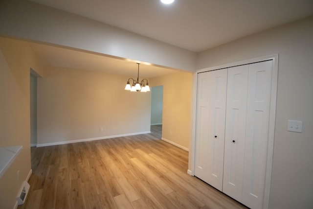 interior space with a closet, light wood-type flooring, and a notable chandelier