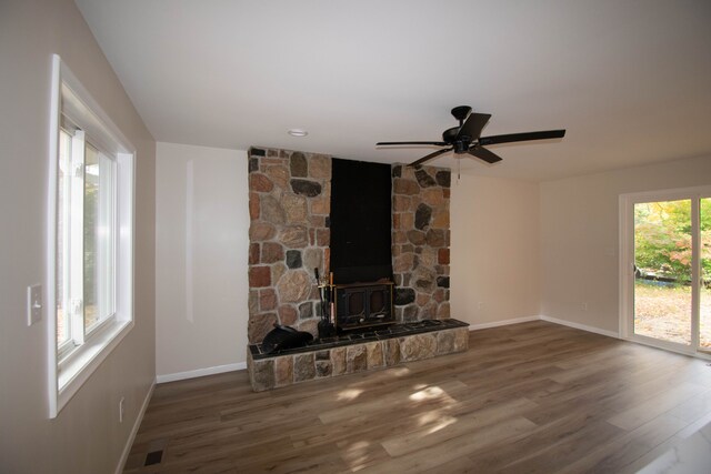 58085 Dulwich, Washington, MI 48094 - unfurnished living room with a wood stove, wood finished floors, and baseboards
