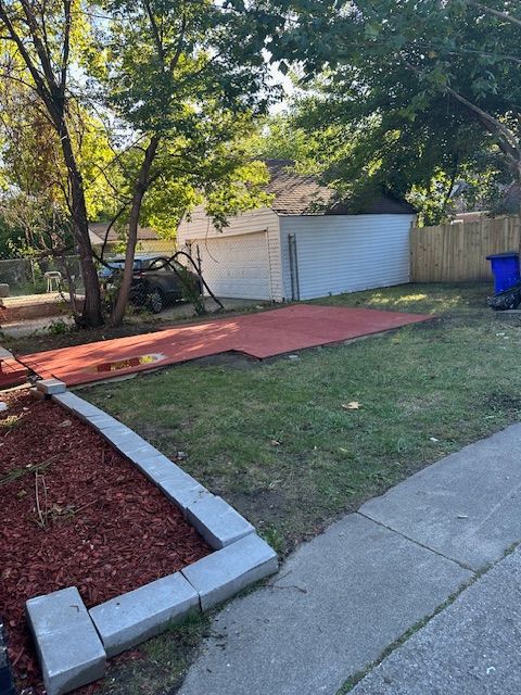 view of yard featuring a garage and an outdoor structure