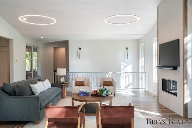 living room with light hardwood / wood-style floors, wooden ceiling, and vaulted ceiling