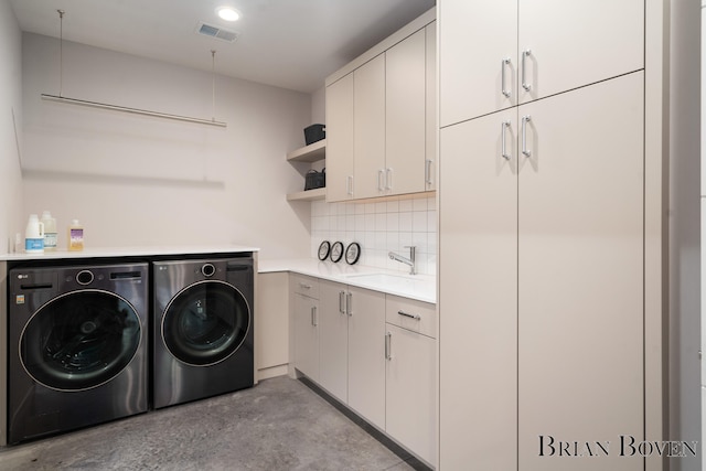 laundry area with cabinets, washer and clothes dryer, and sink