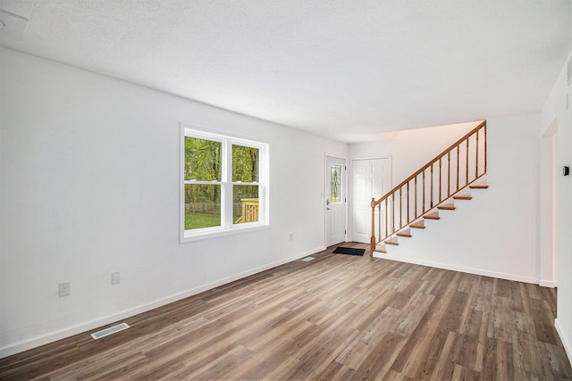 interior space featuring wood-type flooring and a textured ceiling