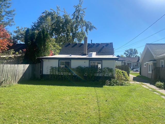 rear view of property with a lawn