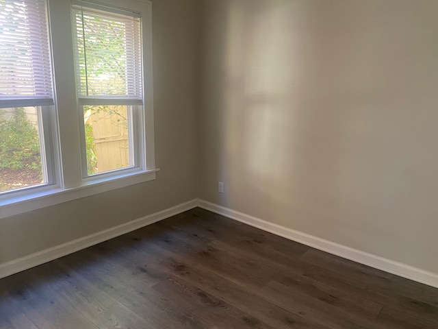 unfurnished room with plenty of natural light and dark hardwood / wood-style floors