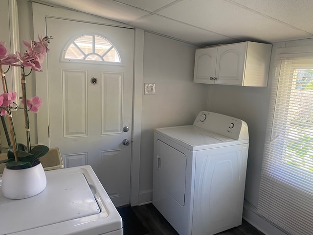 laundry area with washing machine and dryer, plenty of natural light, cabinets, and dark wood-type flooring