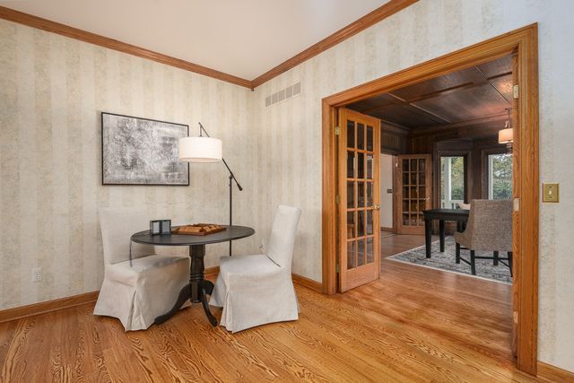 dining area featuring hardwood / wood-style floors, french doors, and crown molding