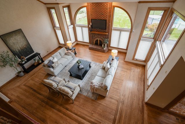 living room with hardwood / wood-style floors and a brick fireplace