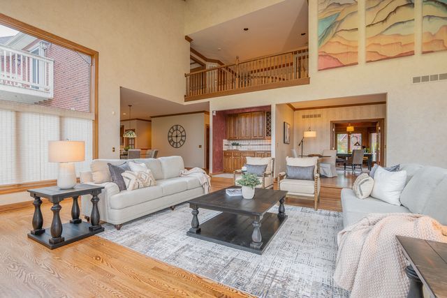 living room with a towering ceiling and hardwood / wood-style flooring