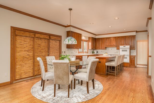 dining area featuring light wood-type flooring and crown molding