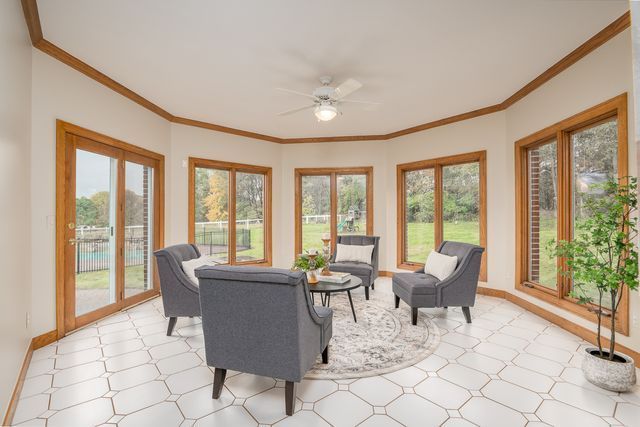 sunroom with a wealth of natural light and ceiling fan