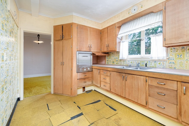 kitchen with pendant lighting, decorative backsplash, ornamental molding, and sink