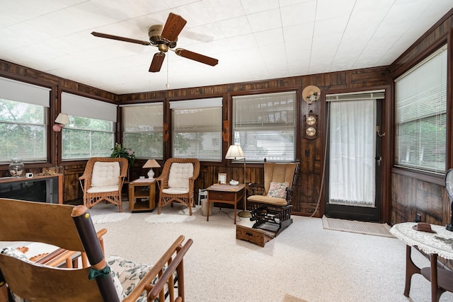 interior space with ceiling fan and wood walls