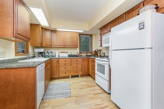 kitchen with white appliances, sink, and light hardwood / wood-style flooring