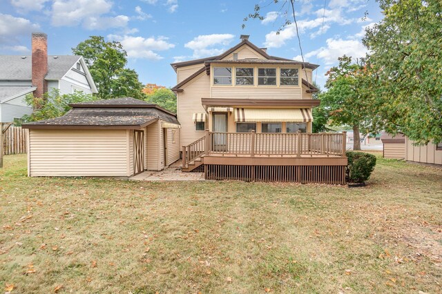 207 N Pine River St, Ithaca, MI 48847 - back of house featuring a deck, a lawn, and an outbuilding