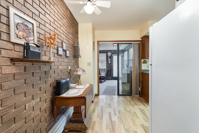 hall featuring light hardwood / wood-style floors and brick wall