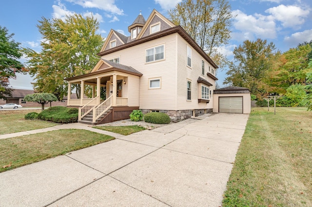 victorian house with an outbuilding, a garage, a front lawn, and covered porch