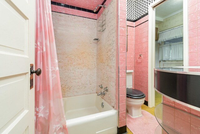 bathroom featuring toilet and shower / tub combo with curtain