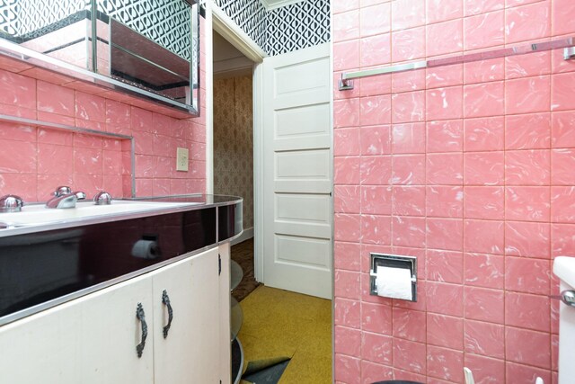 207 N Pine River St, Ithaca, MI 48847 - bathroom with vanity, tile walls, and backsplash