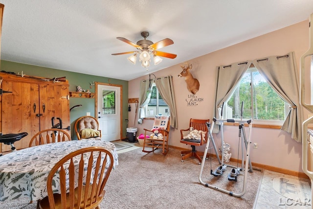 bedroom featuring ceiling fan, light colored carpet, and a textured ceiling