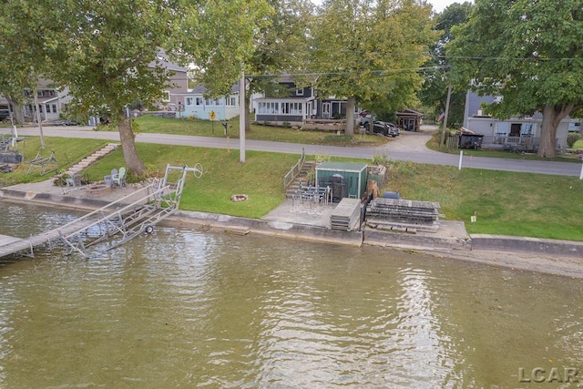 dock area with a water view and a yard