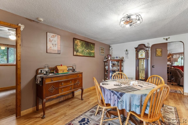 dining area featuring a textured ceiling and light hardwood / wood-style floors