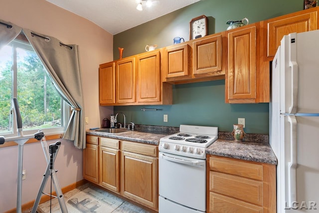 kitchen featuring a textured ceiling, white appliances, and sink