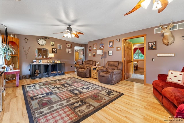 living room featuring a textured ceiling, hardwood / wood-style flooring, and vaulted ceiling