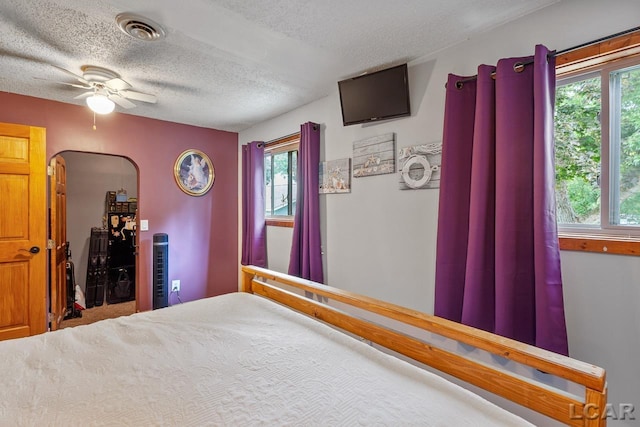 bedroom featuring ceiling fan, carpet floors, and a textured ceiling