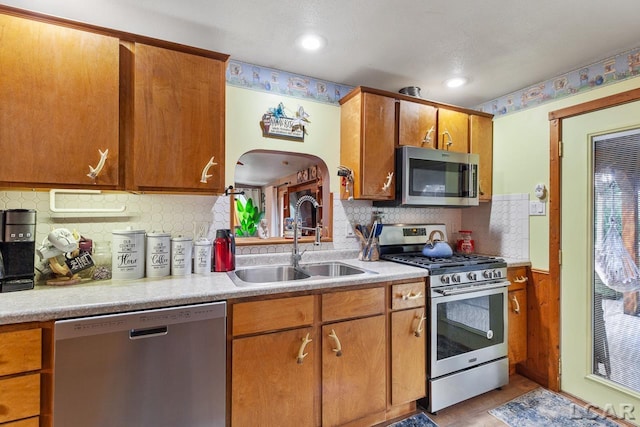 kitchen featuring stainless steel appliances, tasteful backsplash, and sink