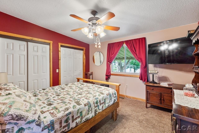 carpeted bedroom featuring multiple closets, a textured ceiling, ceiling fan, and lofted ceiling