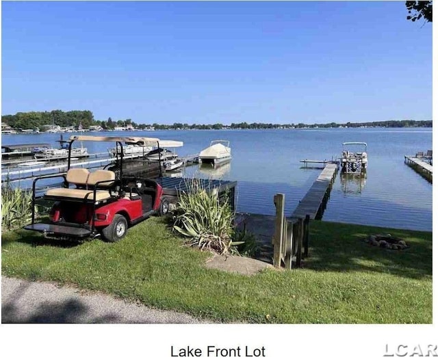 dock area with a yard and a water view