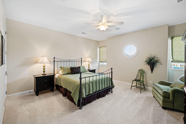 bedroom with a ceiling fan, visible vents, light colored carpet, and baseboards