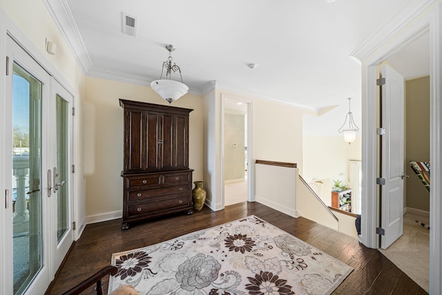 interior space featuring visible vents, ornamental molding, dark wood-type flooring, french doors, and an upstairs landing